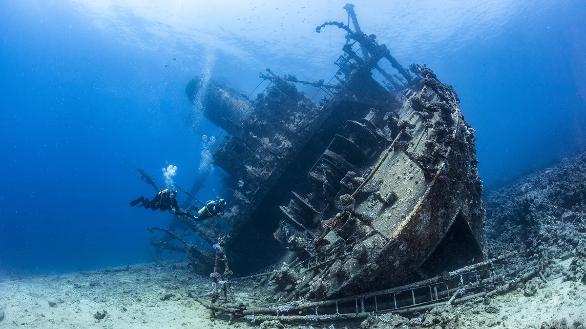 Diver beside a weathered underwater structure off the Dorset coast